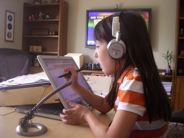 Young Girl with Headphones Writing on Tablet